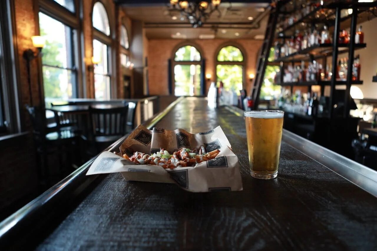 Smoked wings and a draft beer on the long wood bar